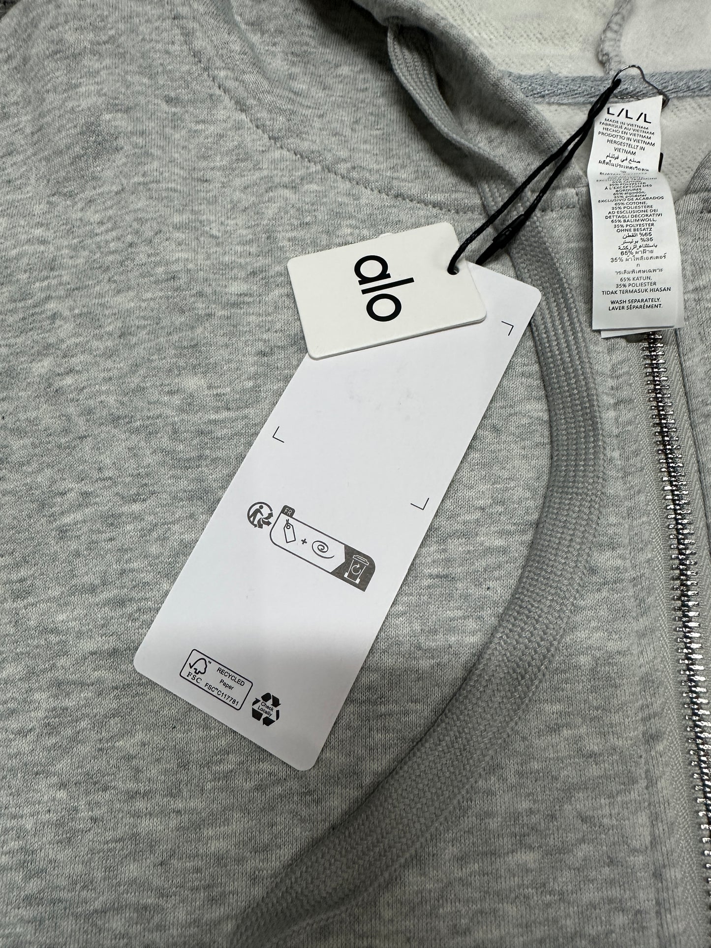 ALO Accolade Athletic Heather Grey hood, neckline and drawstring construction detail
ALO Accolade Athletic Heather Grey full zip hoodie neck label close-up
ALO Accolade Athletic Heather Grey full zip hoodie size label detail
ALO Accolade Athletic Heather Grey full zip hoodie with branded retail hangtags