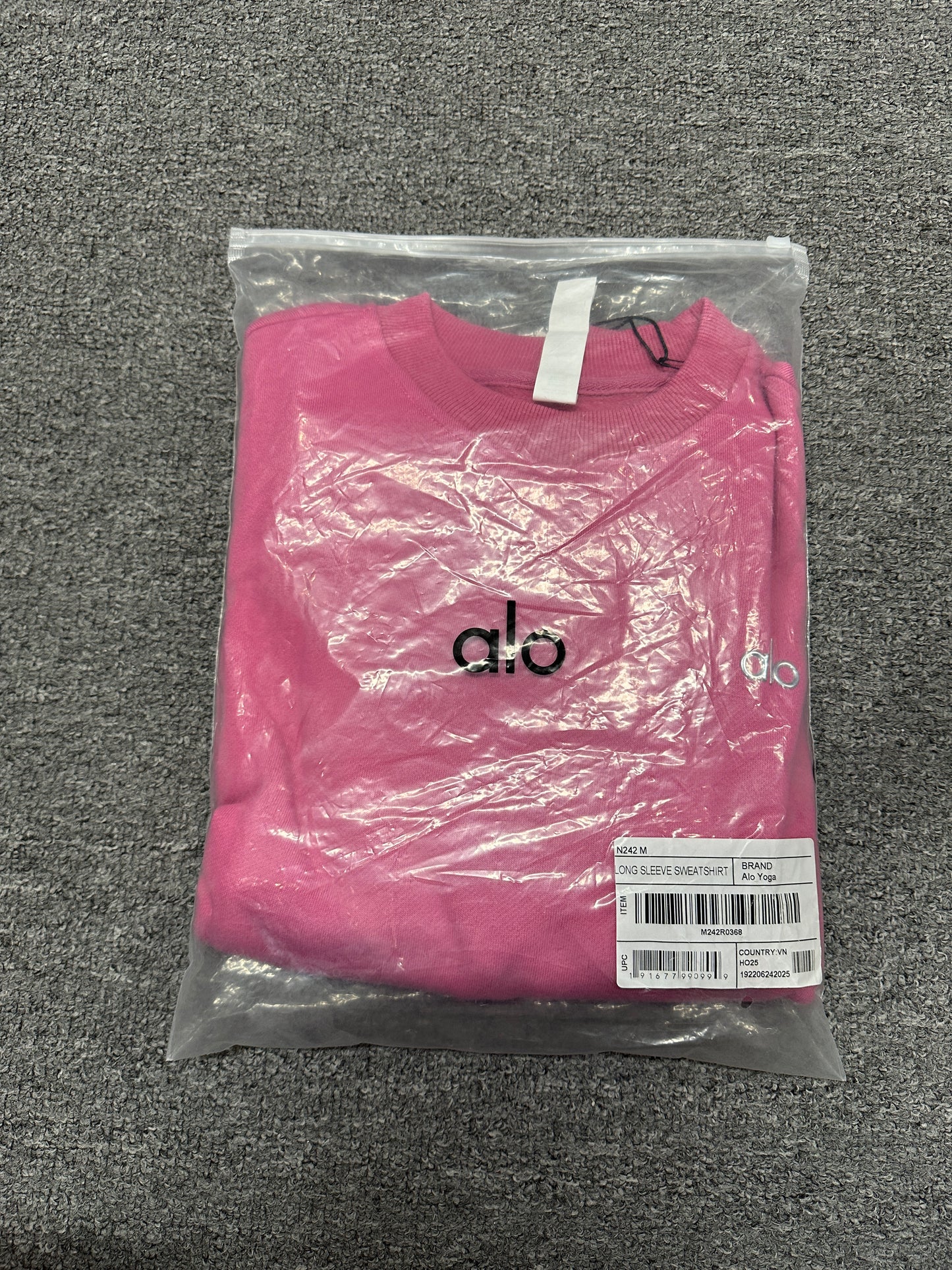 ALO Accolade Paradise Pink crewneck folded inside branded zip packaging bag