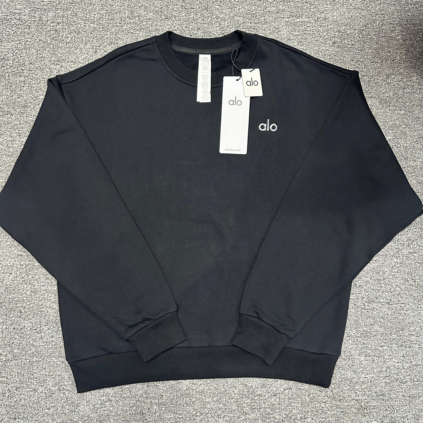 ALO Accolade Crew Neck Pullover in Black front view with silver chest logo
