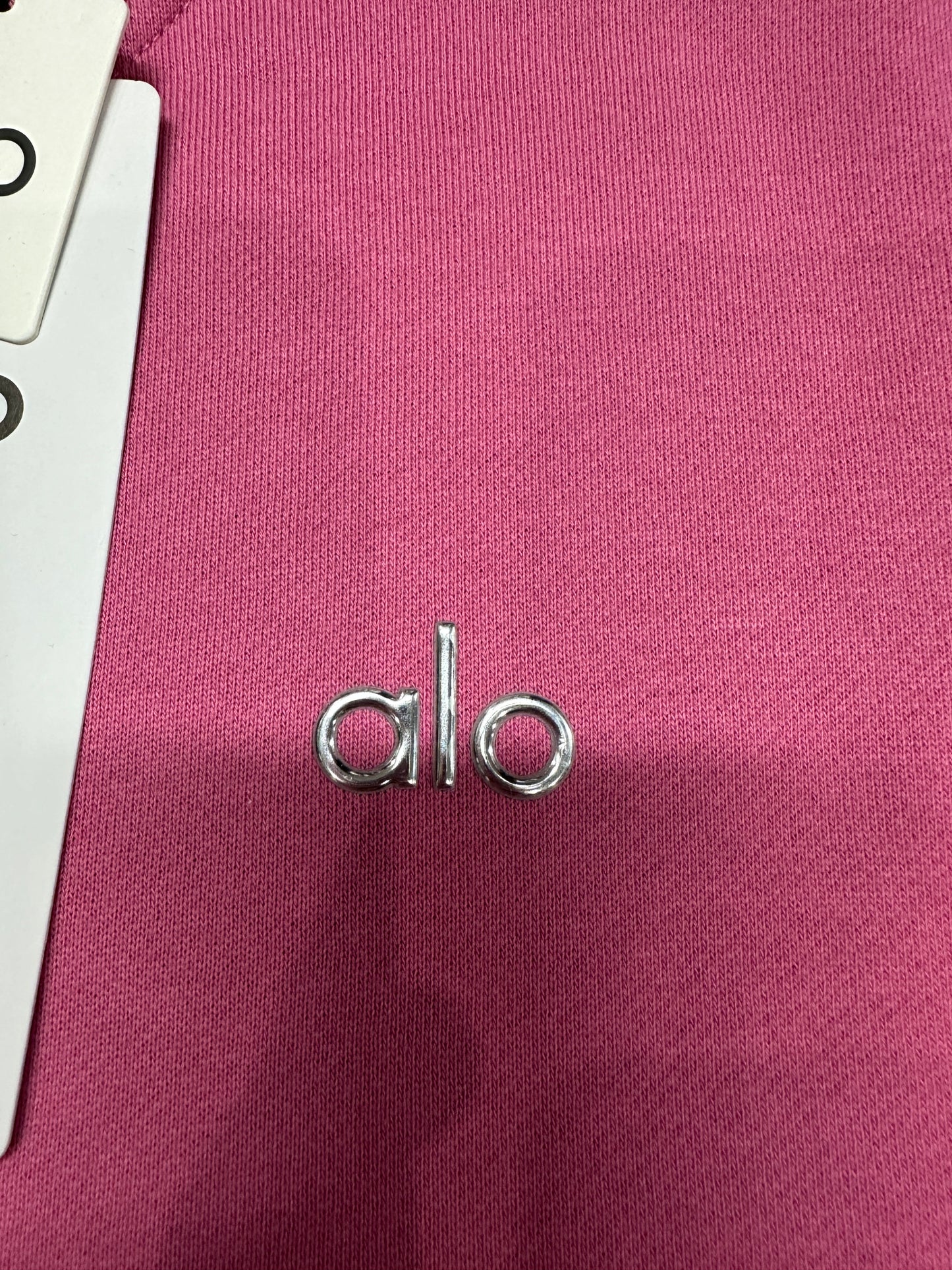 Silver ALO chest logo close-up on Paradise Pink Accolade Crew Neck Pullover