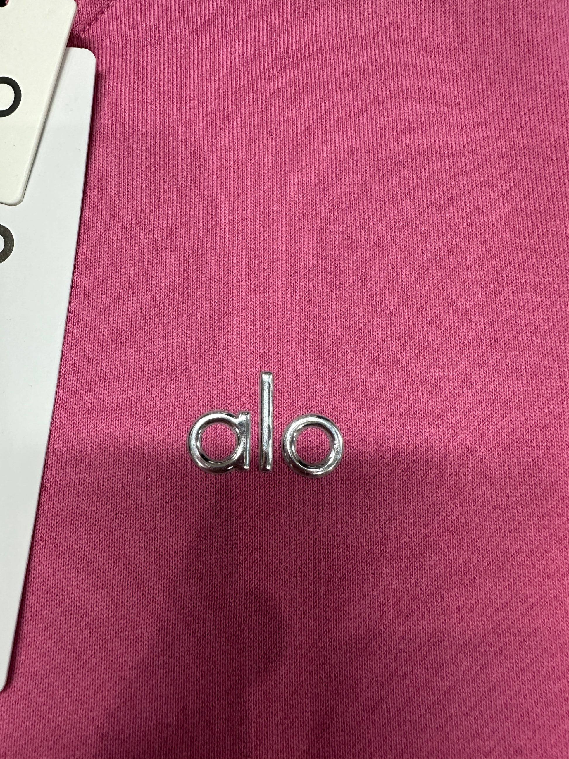 Silver ALO chest logo close-up on Paradise Pink Accolade Crew Neck Pullover