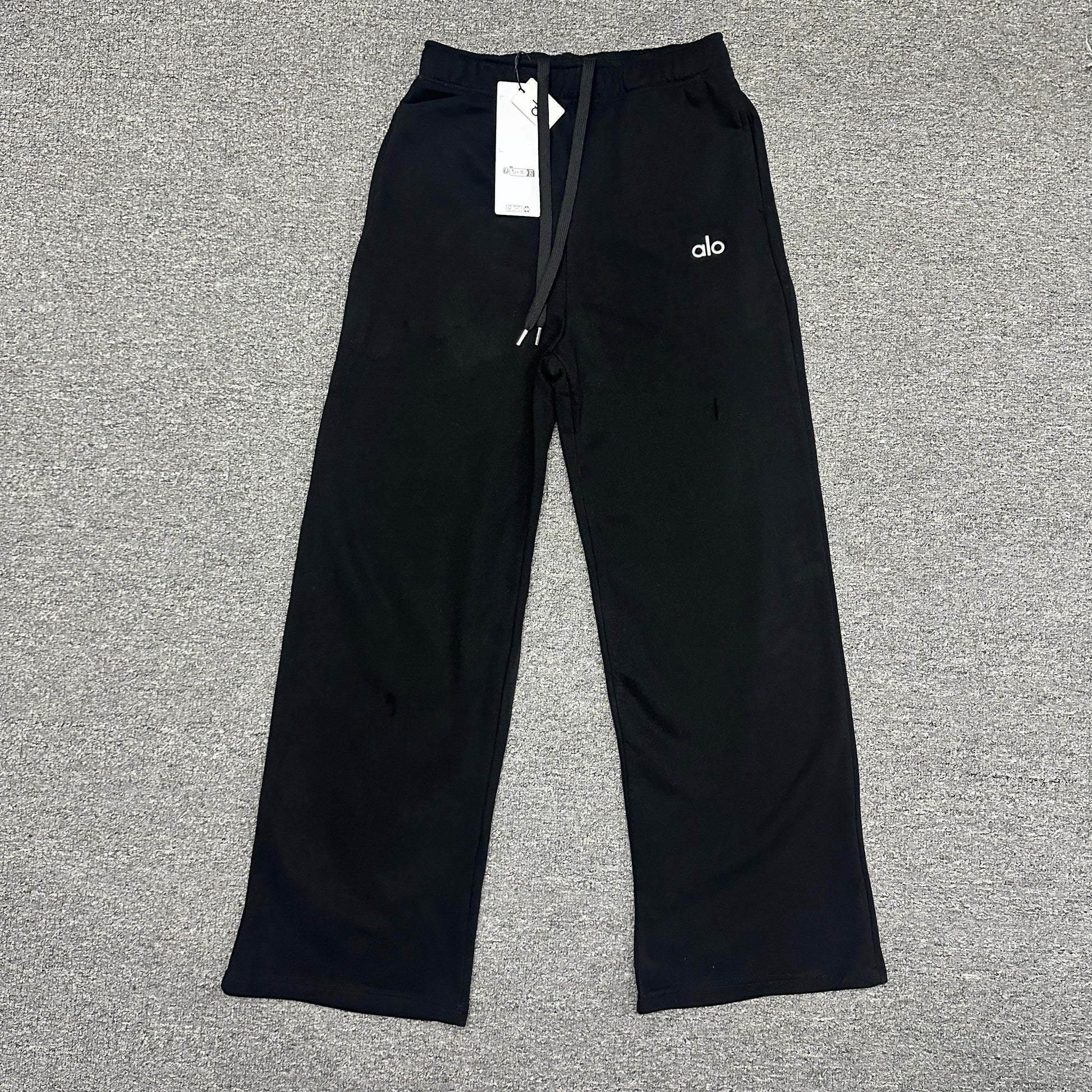 ALO Accolade Straight Leg Sweatpant in Black front view with chrome logo detail