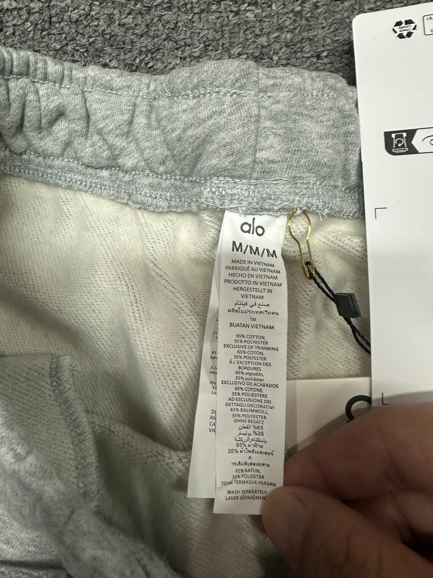 Alo Yoga Accolade Sweatpants Elastic Waistband and Metal-Tipped Drawstrings Detail
Alo Yoga Accolade Sweatpants Woven Size Tag and Waist Label
Alo Yoga Authentic Retail Hangtag with Barcode Tag
Alo Yoga Wash Care Tag Cotton Polyester Fabric Info
