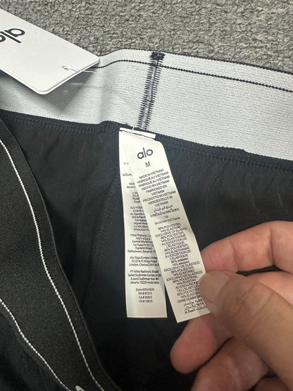 Alo Yoga Pursuit Trouser Elastic Contrast Striped Waistband Stitching Detail
Alo Yoga Pursuit Trouser Inner Woven Waist Tag and Size Label
Alo Yoga Authentic Retail Hangtag with Barcode Tag
Alo Yoga Care Label Polyester Spandex Fabric Washing Instructions

