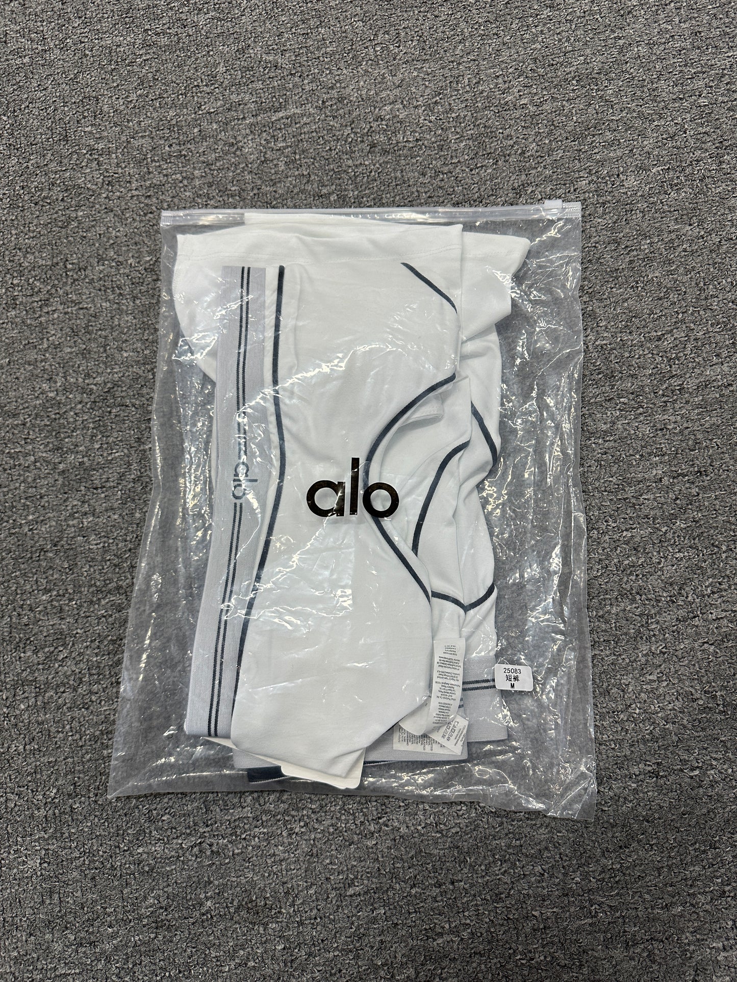 ALO Heart Throb White Black two-piece set folded inside branded packaging bag