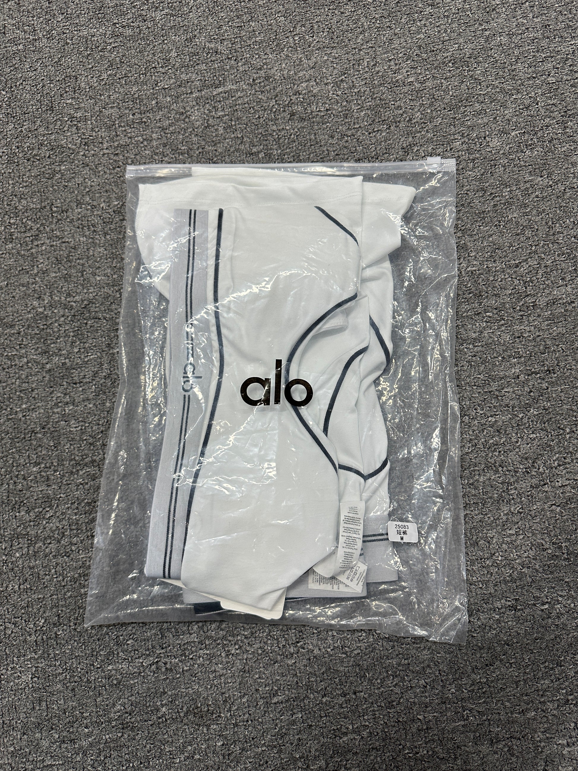 ALO Heart Throb White Black two-piece set folded inside branded packaging bag