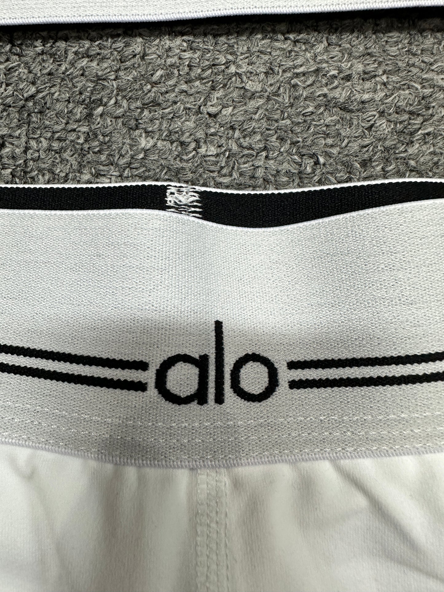 ALO logo elastic band close-up on White Black Heart Throb workout set
ALO Heart Throb White Black short elastic logo waistband construction detail