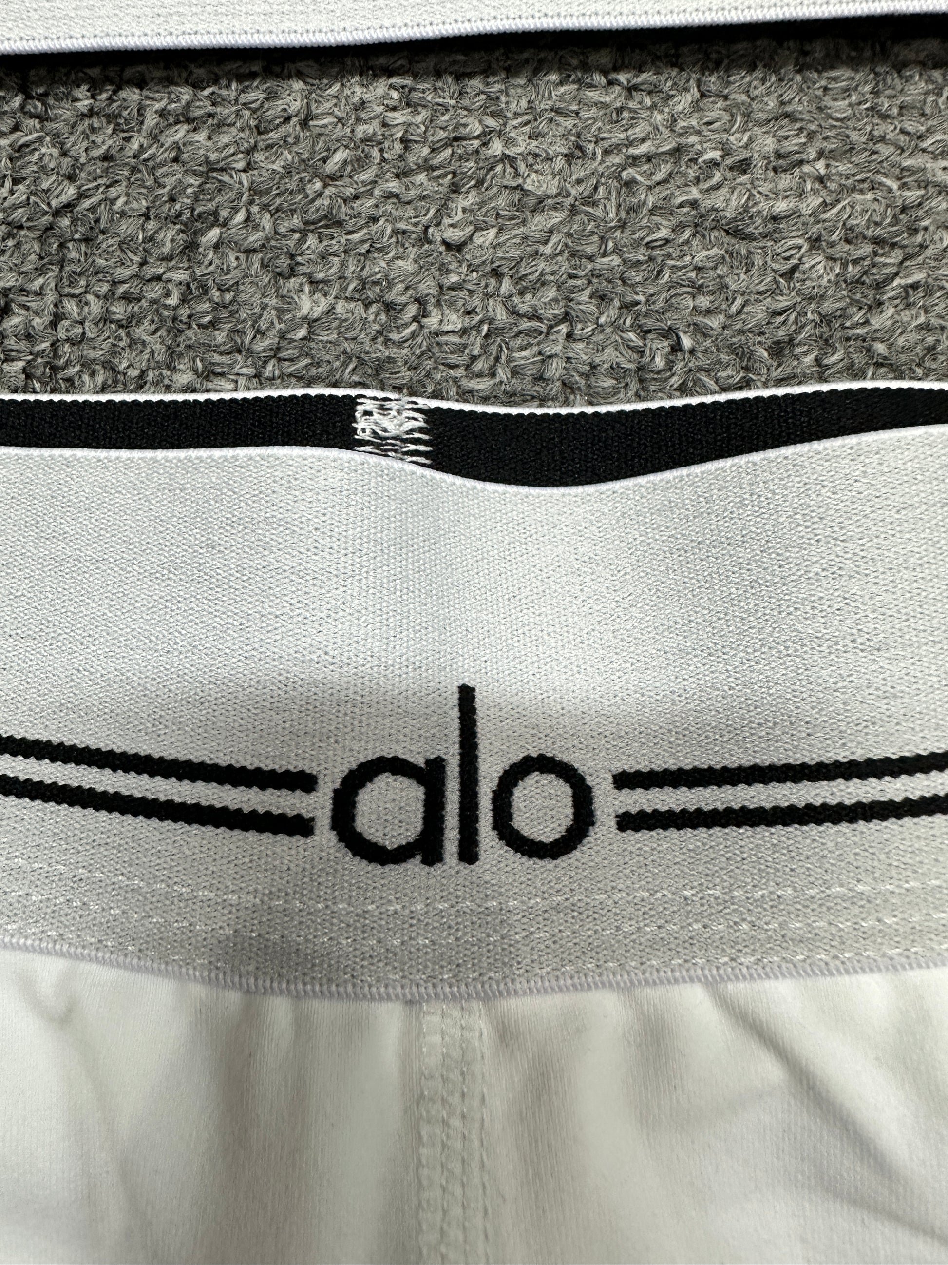 ALO logo elastic band close-up on White Black Heart Throb workout set
ALO Heart Throb White Black short elastic logo waistband construction detail