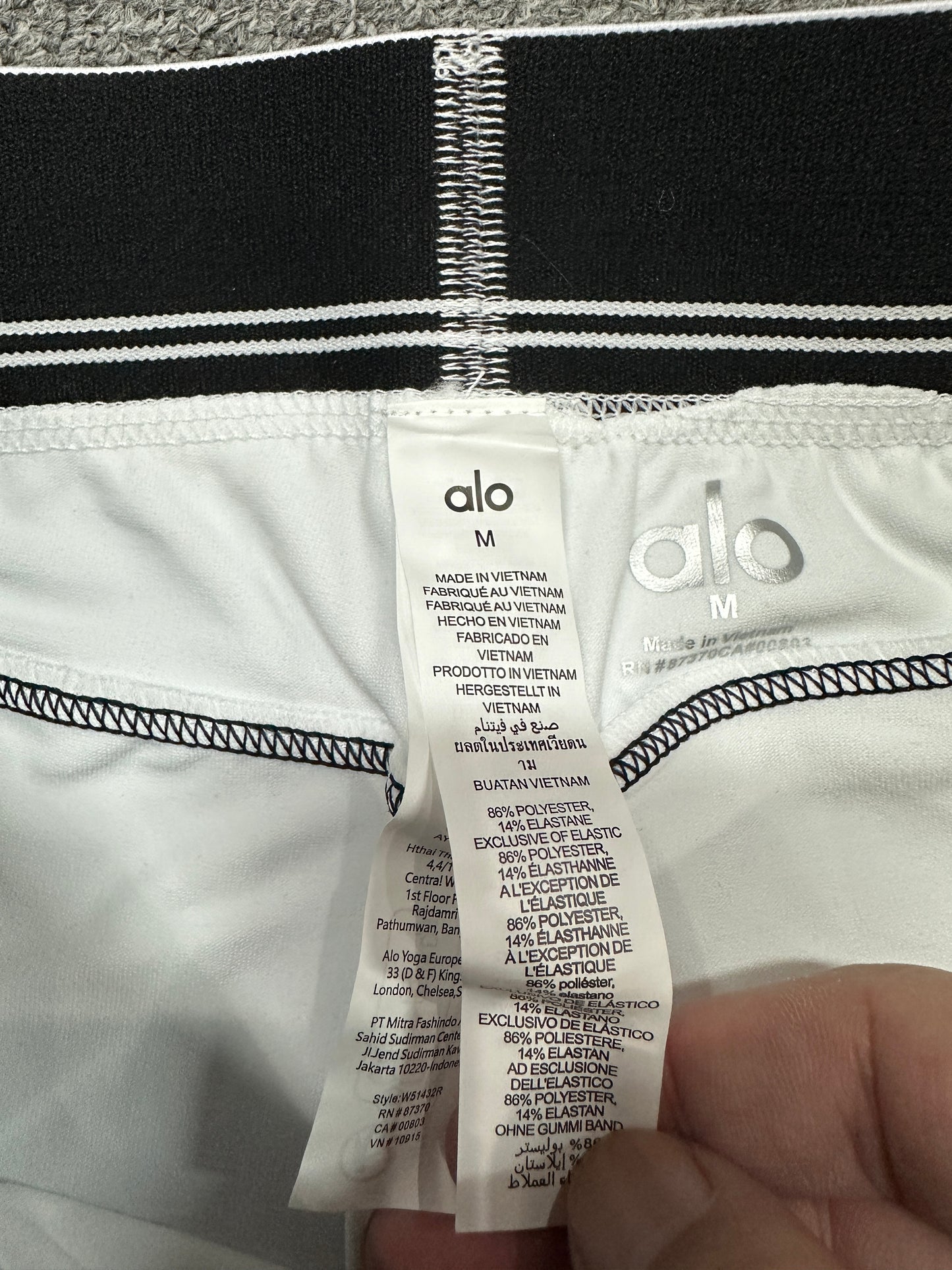 ALO Heart Throb White Black short elastic logo waistband construction detail
ALO Heart Throb White Black set inner label and size label detail
ALO Heart Throb White Black activewear set care label and fabric information
ALO logo elastic band close-up on White Black Heart Throb workout set
ALO Airbrush Heart Throb White Black stretch fabric inner surface close-up