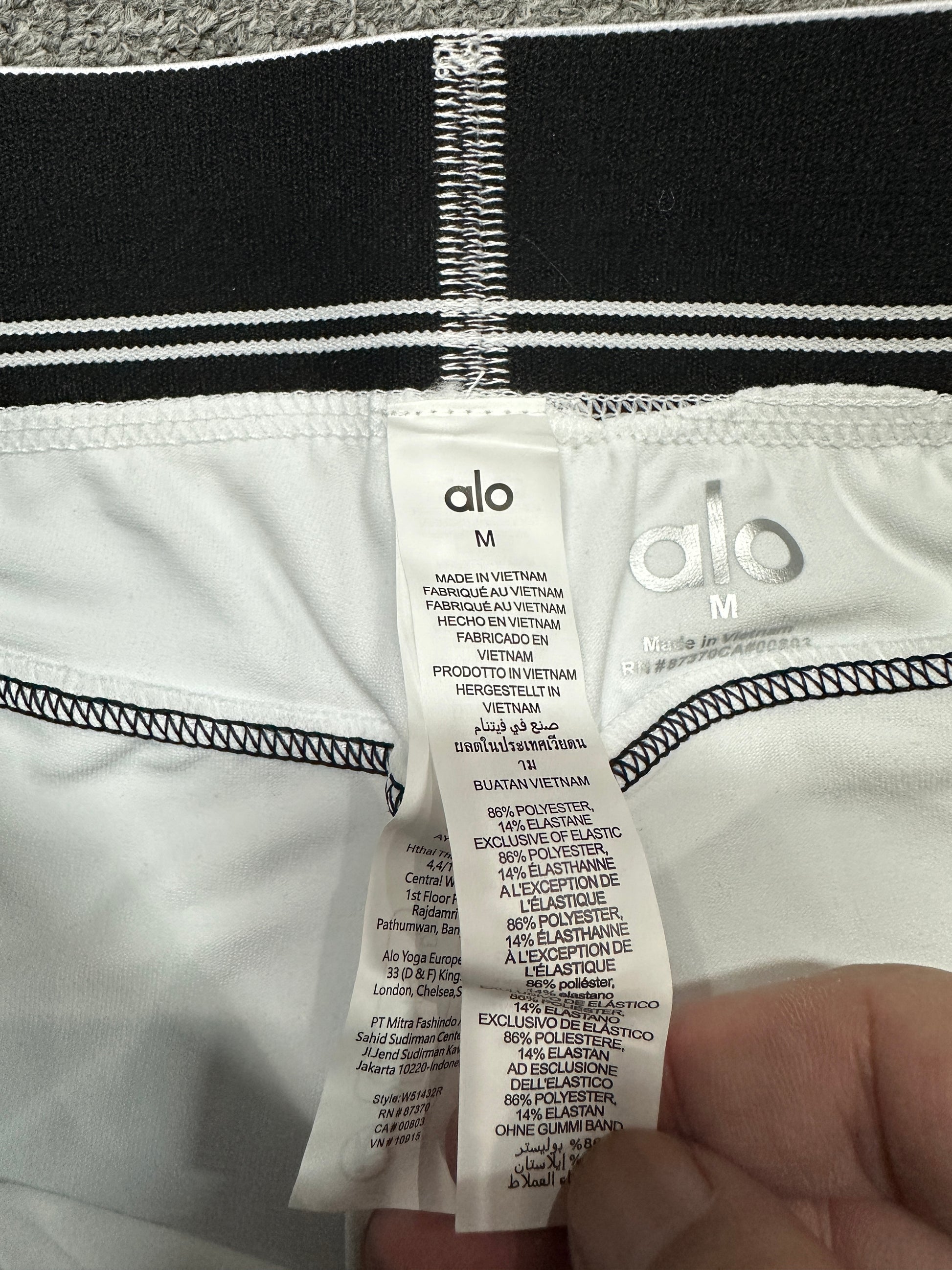 ALO Heart Throb White Black short elastic logo waistband construction detail
ALO Heart Throb White Black set inner label and size label detail
ALO Heart Throb White Black activewear set care label and fabric information
ALO logo elastic band close-up on White Black Heart Throb workout set
ALO Airbrush Heart Throb White Black stretch fabric inner surface close-up