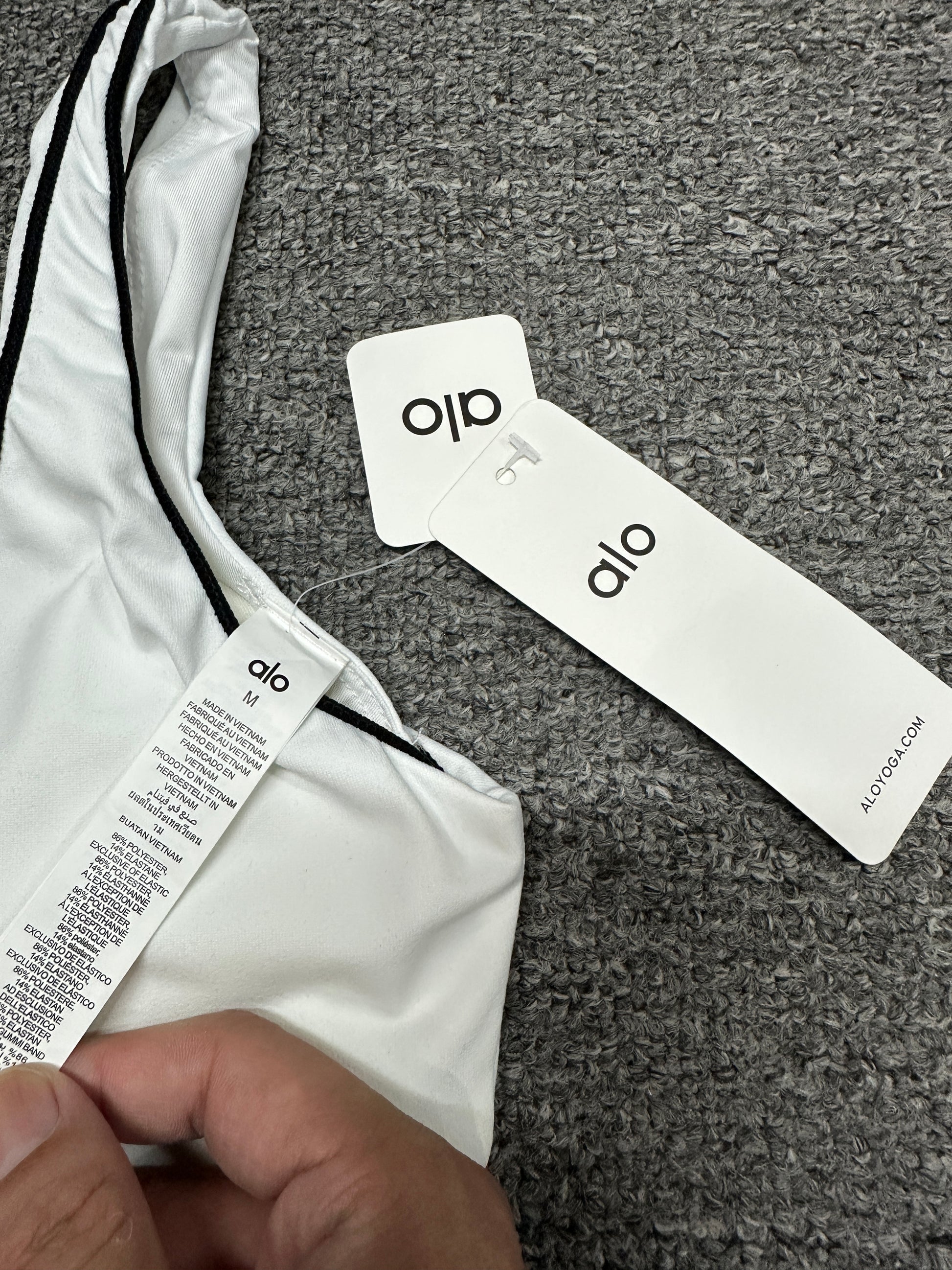 ALO Airbrush Heart Throb White Black bra scoop neckline and contrast piping detail
ALO Heart Throb White Black sports bra shoulder strap stitching detail
ALO Airbrush Heart Throb White Black workout set with retail hangtags