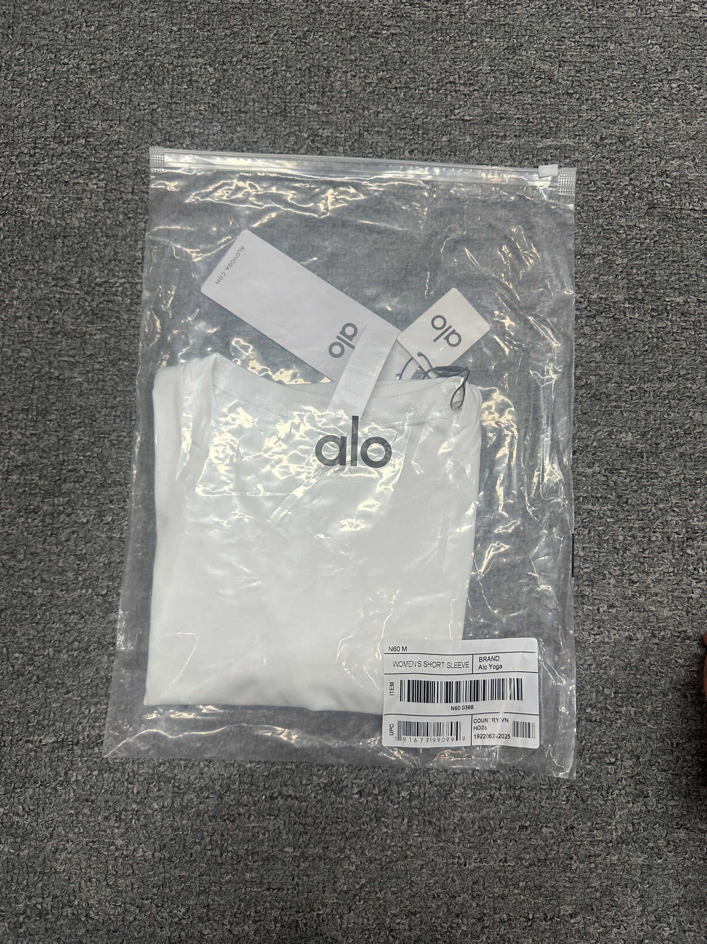 ALO Alosoft White crop tee folded inside branded packaging bag