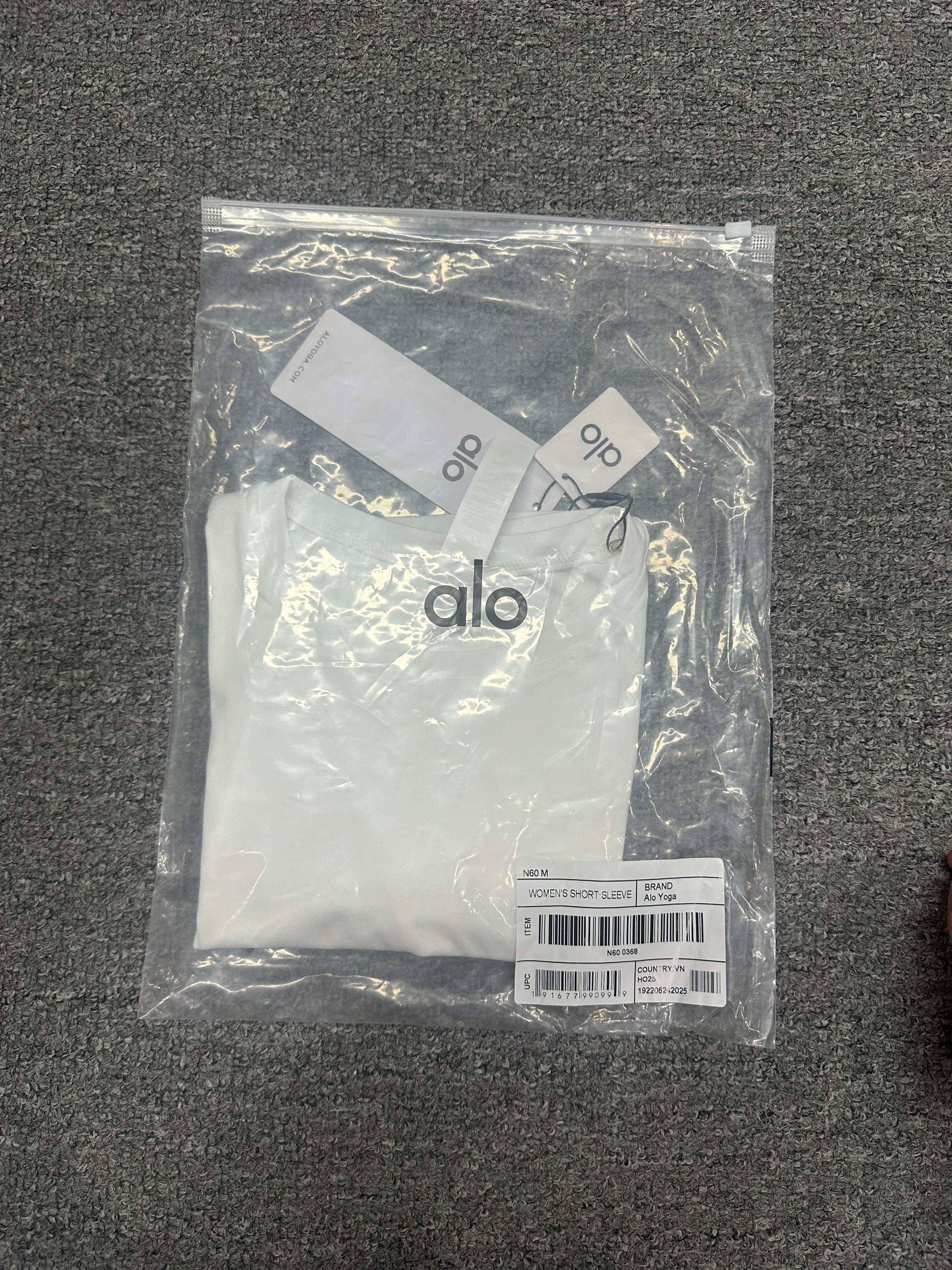ALO Alosoft White crop tee folded inside branded packaging bag