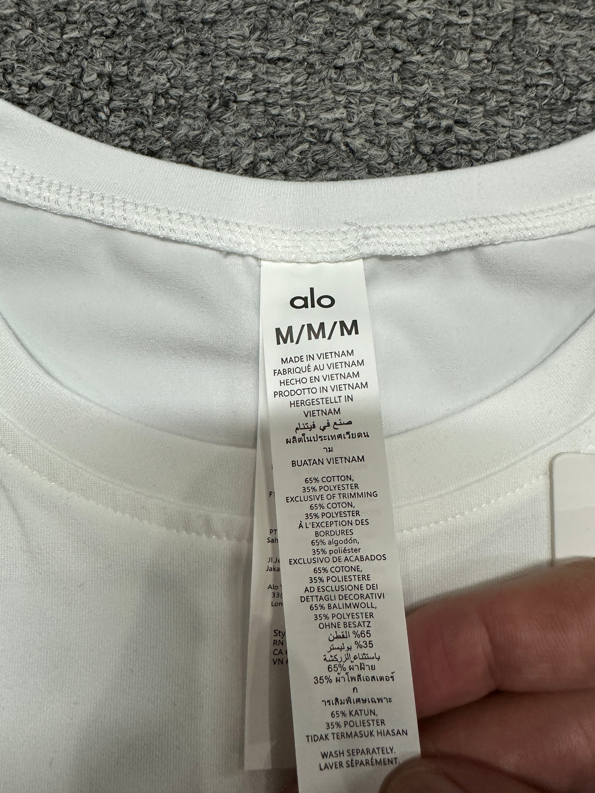 ALO Alosoft White crop tee crew neckline and stitching detail
ALO Alosoft White crop tee neck label and size label close-up
ALO Alosoft White crop tee care label and fabric information detail