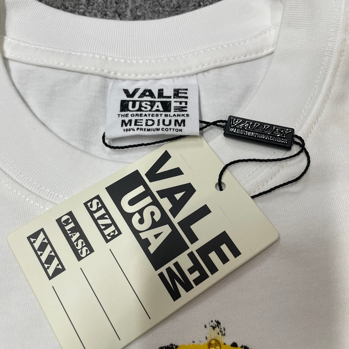 Vale Forever Valley Dreams Alien T-Shirt branded neck label detail
Vale Forever Valley Dreams Alien Graphic Tee size label close-up
Vale Forever Valley Dreams Alien Rhinestone Tee branded hang tag detail