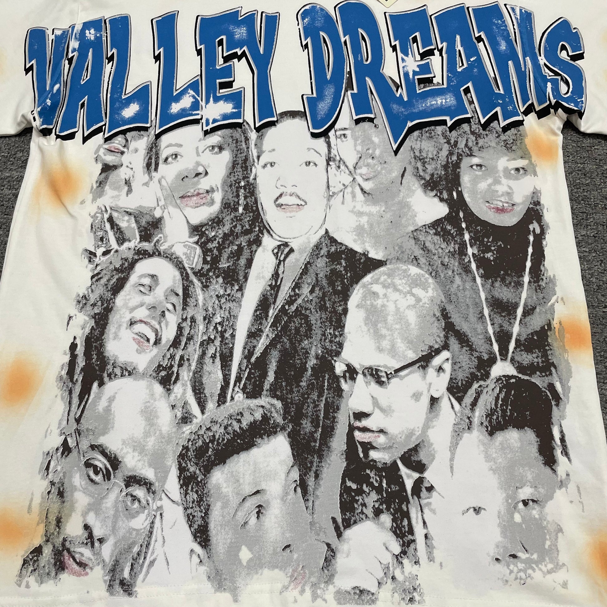 Vale Forever Americas Dream Tee full portrait collage front graphic
Americas Dream Bling Tee black and white portrait collage graphic
Vale Forever Americas Dream Tee distressed portrait print detail
Vale Forever Americas Dream Tee oversized blue Valley Dreams lettering
Americas Dream Bling Tee blue lettering embellishment close-up
Vale Forever Americas Dream Tee orange spray wash front detail
Vale Forever Americas Dream Bling Tee cream vintage fabric finish