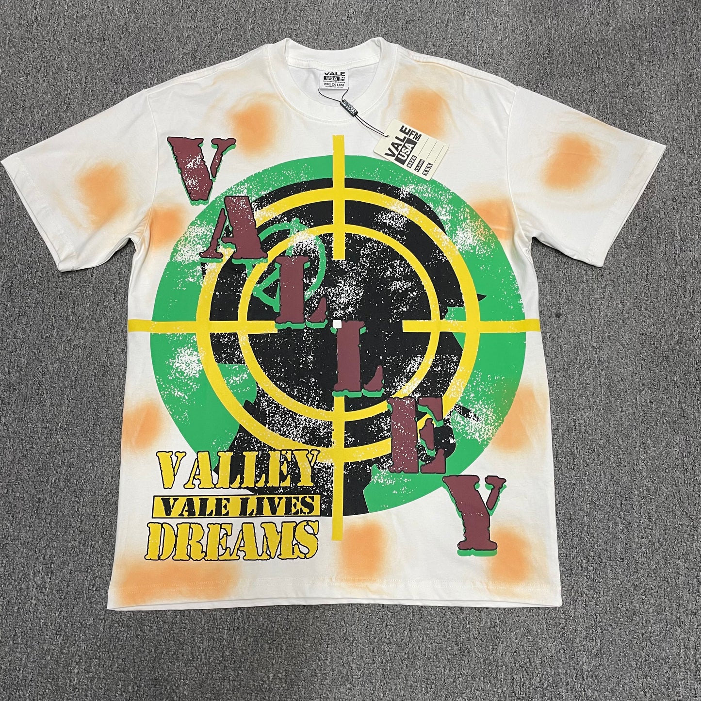 Vale Forever Target Tee Cream front view with Valley Dreams graphic
Vale Forever Target Tee full crosshair and Valley Dreams front graphic
Vale Forever Target Tee oversized green black and yellow target graphic
Vale Forever Target Tee distressed vintage graphic print close-up
Vale Forever Target Tee green and black crosshair graphic detail
Vale Forever Target Tee yellow crosshair print detail
Vale Forever Target Tee distressed vertical Valley lettering detail