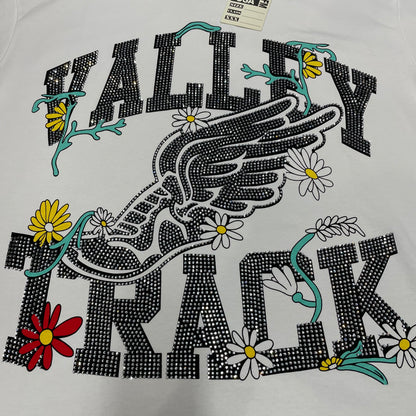 Vale Forever Valley Track Tee full winged shoe and floral front graphic
Vale Forever Valley Track Tee winged track-shoe and floral artwork
Vale Forever Valley Track Tee detailed floral and wing graphic close-up
Vale Forever Valley Track Tee crystal Valley lettering detail
Vale Forever Valley Track Tee crystal Track lettering detail
Vale Forever Valley Track Tee black crystal embellishment close-up
Vale Forever Valley Track Tee winged running shoe graphic detail