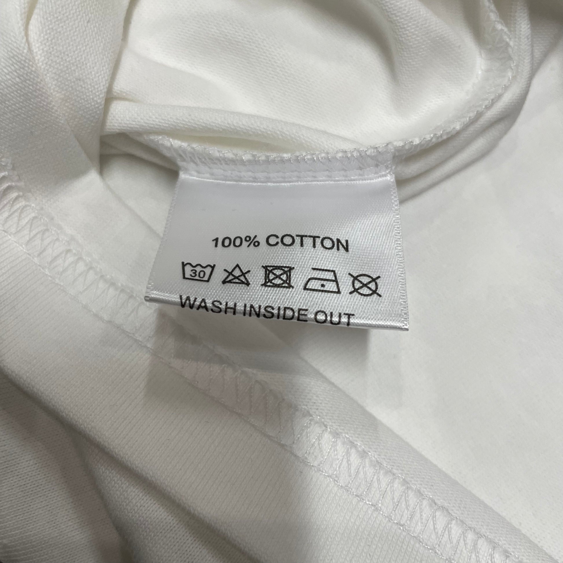 Vale Forever Valley Track Tee double stitched bottom hem detail
Vale Forever Valley Track Wing Bling Tee wash care label close-up