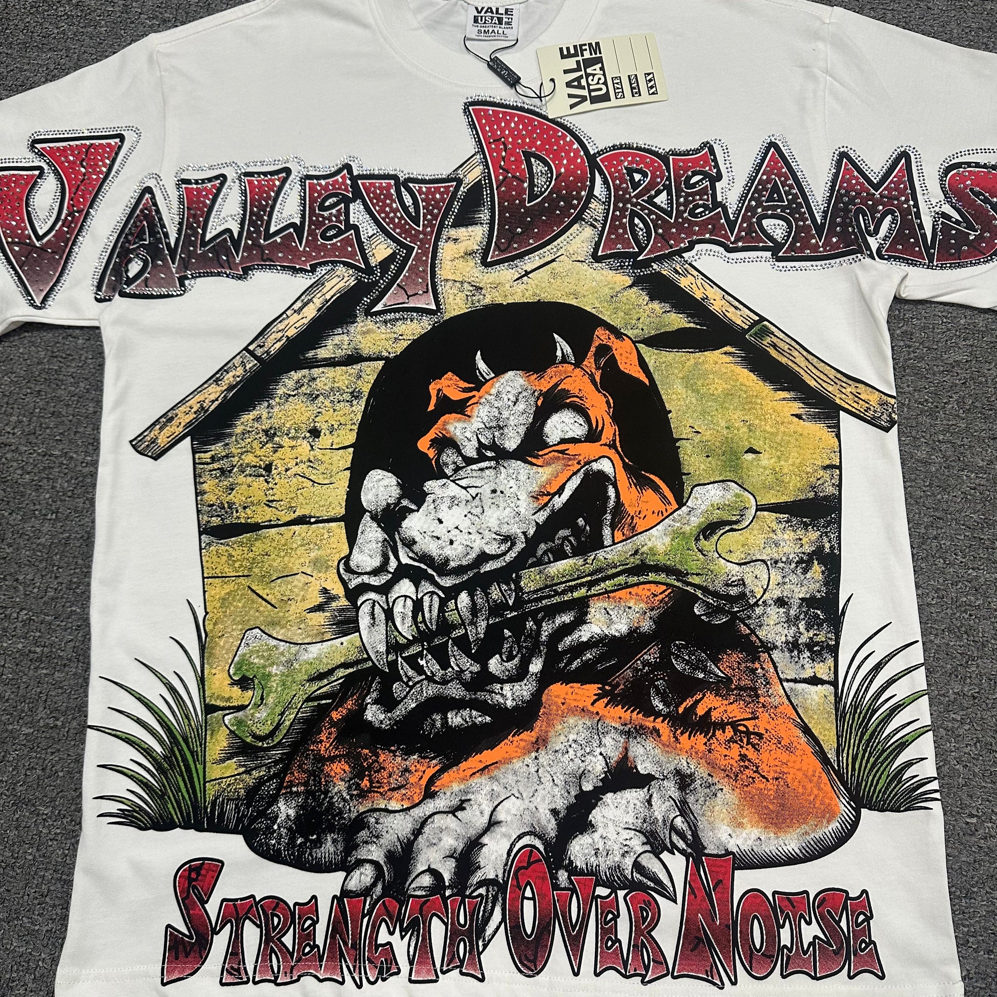 Vale Forever Dog of War Bling Tee full bulldog front graphic
Vale Forever Dog of War Bling Tee bulldog and doghouse artwork
Vale Forever Dog of War Bling Tee distressed graphic print close-up
Vale Forever Dog of War Bling Tee crystal Valley Dreams lettering
Vale Forever Dog of War Bling Tee rhinestone lettering close-up
Vale Forever Dog of War Bling Tee red crystal Valley lettering detail