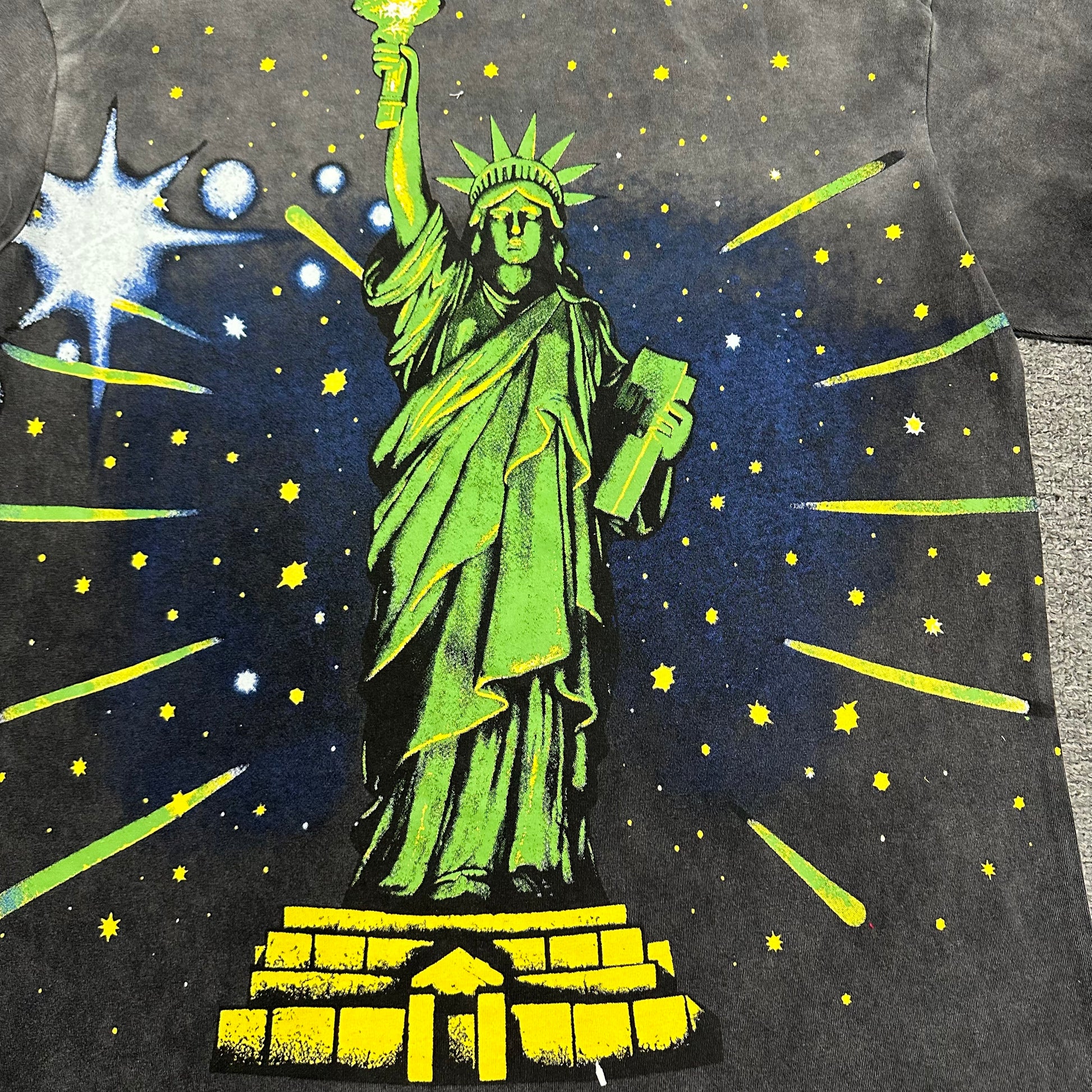 Vale Forever Skyline Bling Tee full Statue of Liberty back graphic
Vale Forever Skyline Bling Tee starry Statue of Liberty back artwork
Vale Forever Skyline Bling Tee Statue of Liberty and starry sky print detail
Vale Forever Skyline Bling Tee oversized green Statue of Liberty back print