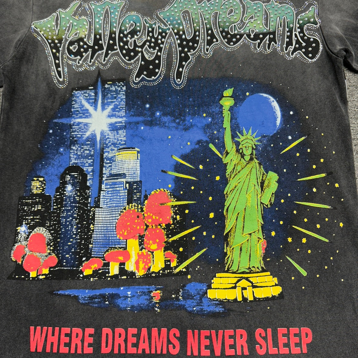 Vale Forever Skyline Bling Tee full NYC skyline front graphic
Vale Forever Skyline Bling Tee NYC skyline and Statue of Liberty artwork
Vale Forever Skyline Bling Tee detailed New York night skyline print
Vale Forever Skyline Bling Tee crystal Valley Dreams lettering
Vale Forever Skyline Bling Tee rhinestone lettering close-up
Vale Forever Skyline Bling Tee green Statue of Liberty front graphic