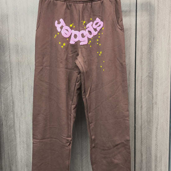 SP5DER Classic brown sweatpants front view with pink logo and yellow star graphics