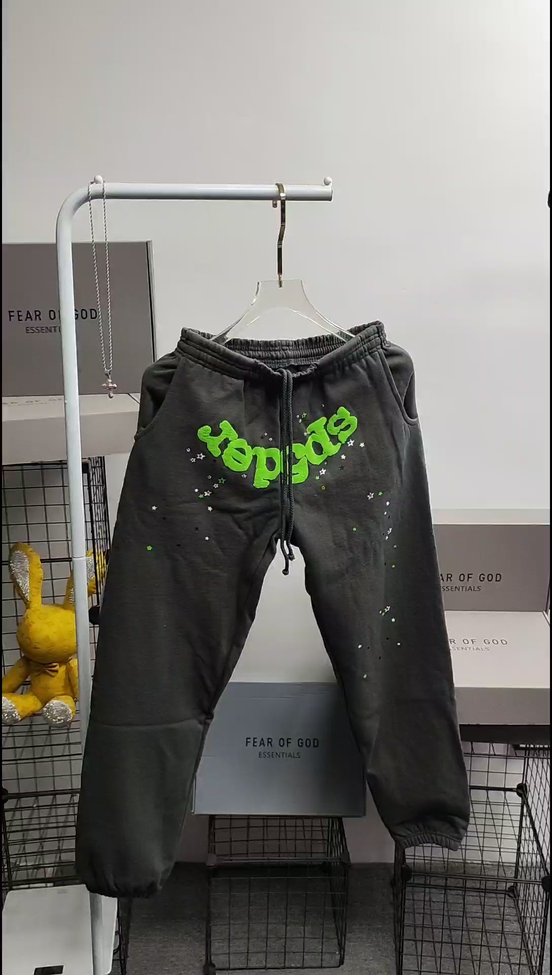 SP5DER Wait Web slate grey sweatpants front view with neon green logo and scattered stars