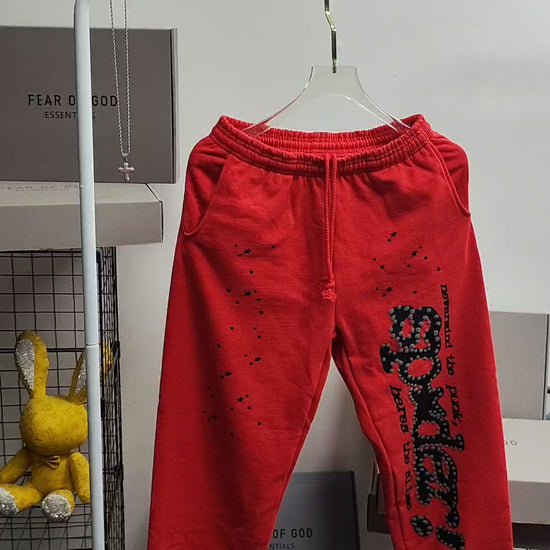 SP5DER P*NK V2 red sweatpants front view with black leg graphic and scattered stars
