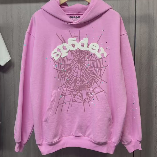 Sp5der OG Web Hoodie Pink front view with raised white logo, dark web graphic and multicolor stars