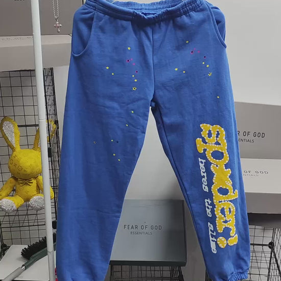 SP5DER TC Blue sweatpants front view with yellow leg graphic and multicolor star details
