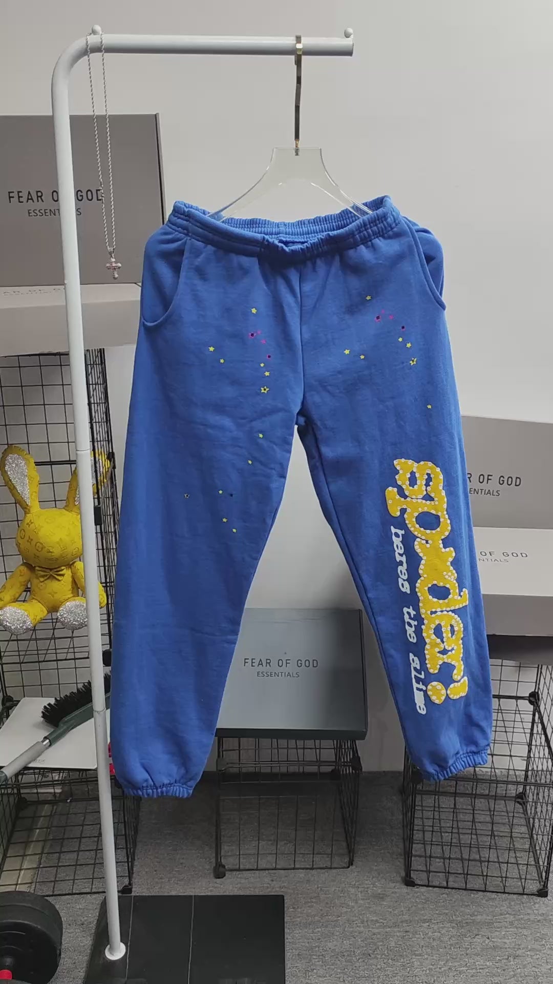 SP5DER TC Blue sweatpants front view with yellow leg graphic and multicolor star details