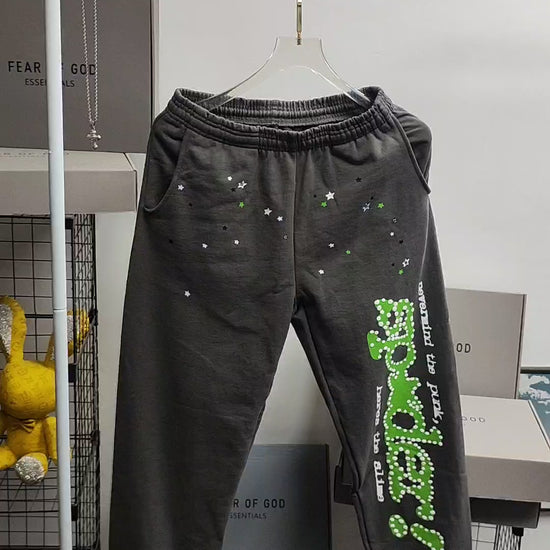 SP5DER Punk V2 slate grey sweatpants front view with green leg graphic and scattered stars